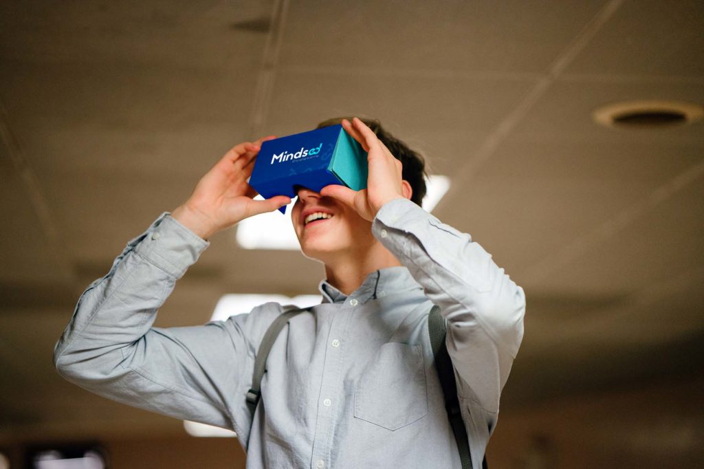 young male learner immersed using cardboard vr glasses